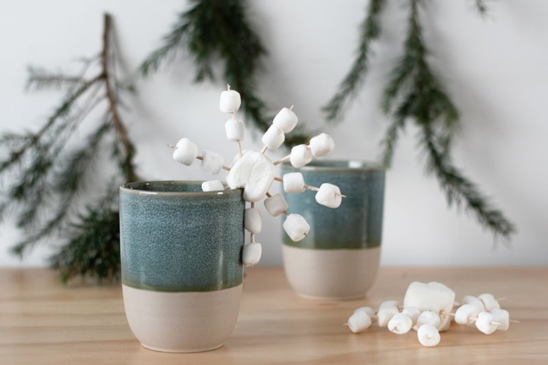 sneeuwvlokken van marshmallows op een mok met chocolademelk