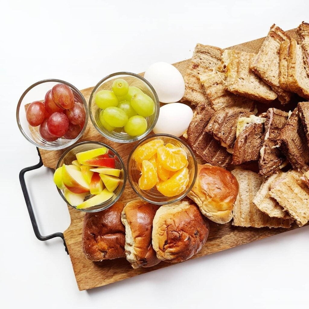 Een gezellige lunchplank met krentenbollen, tosti's en fruit