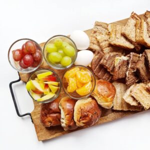 Een gezellige lunchplank met krentenbollen, tosti's en fruit